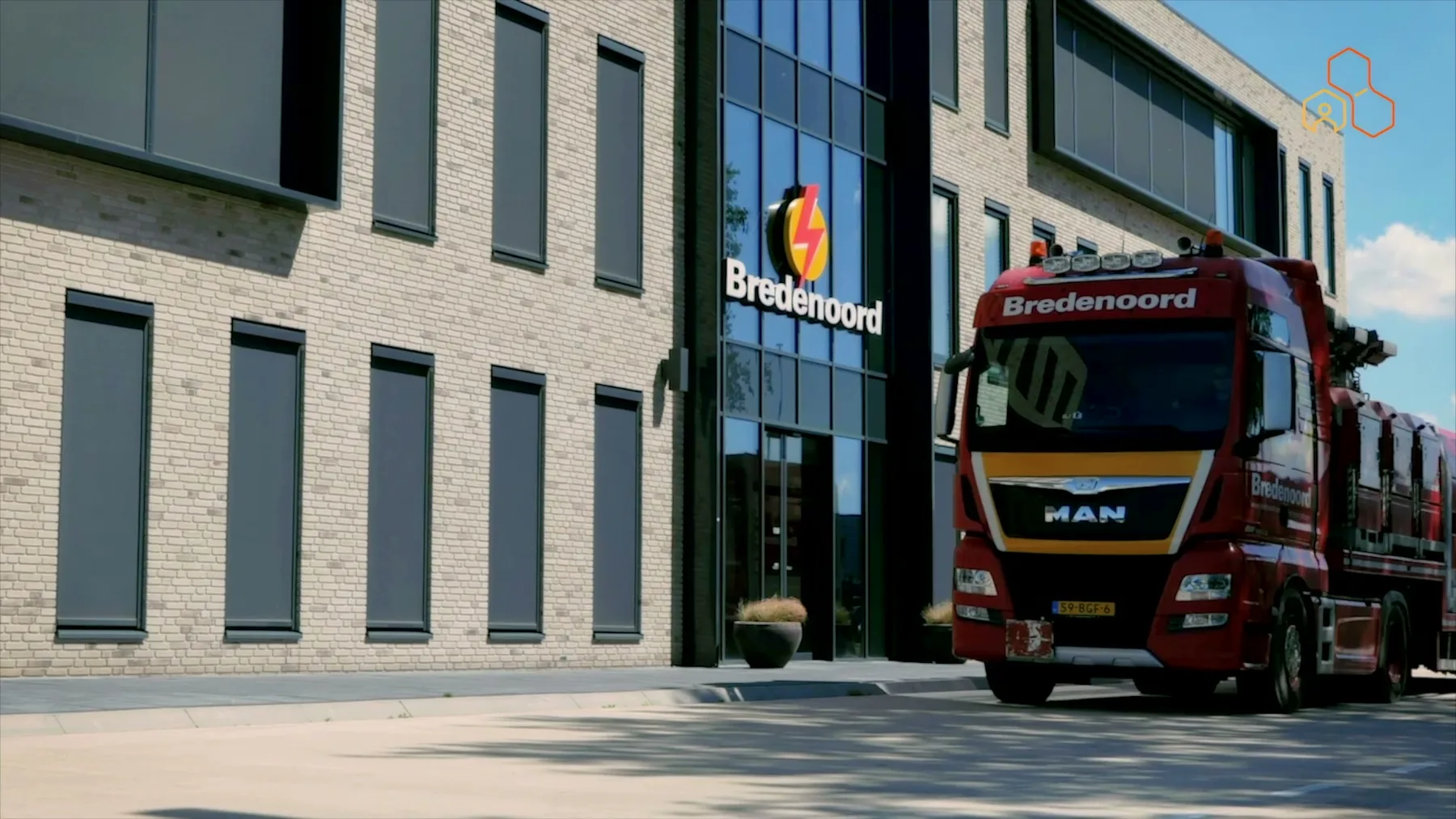 Het kantoorpand van Bredenoord, met een vrachtwagen vol rode verhuurunits ervoor.